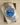 Angled view of the Rolex Datejust 41 reference 126300 sitting inside its display cushion, showing the blue Roman numeral dial, date window, and smooth stainless steel bezel