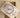41mm rose gold and steel Rolex Datejust watch with a sundust diamond dial displayed at an angle resting on its tan leather watch pillow