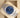 An angled top-down view of an Oystersteel Rolex Oyster Perpetual 36 126000 blue dial watch resting inside its beige leather presentation cushion