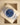 An angled top-down view of an Oystersteel Rolex Oyster Perpetual 36 126000 blue dial watch resting inside its beige leather presentation cushion