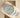 angled top-down view of the steel 41mm Rolex Oyster Perpetual watch with a pistachio lacquer dial resting on its cream leather display cushion