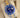 angled view of a 2002 two-tone Rolex Submariner reference 16613 showing its vibrant blue face, gold hands, and aluminum timing bezel on a cushion