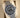 angled view of the 2026 Rolex Yacht-Master 42 titanium watch showing the bidirectional rotating bezel with raised polished numerals on a presentation cushion